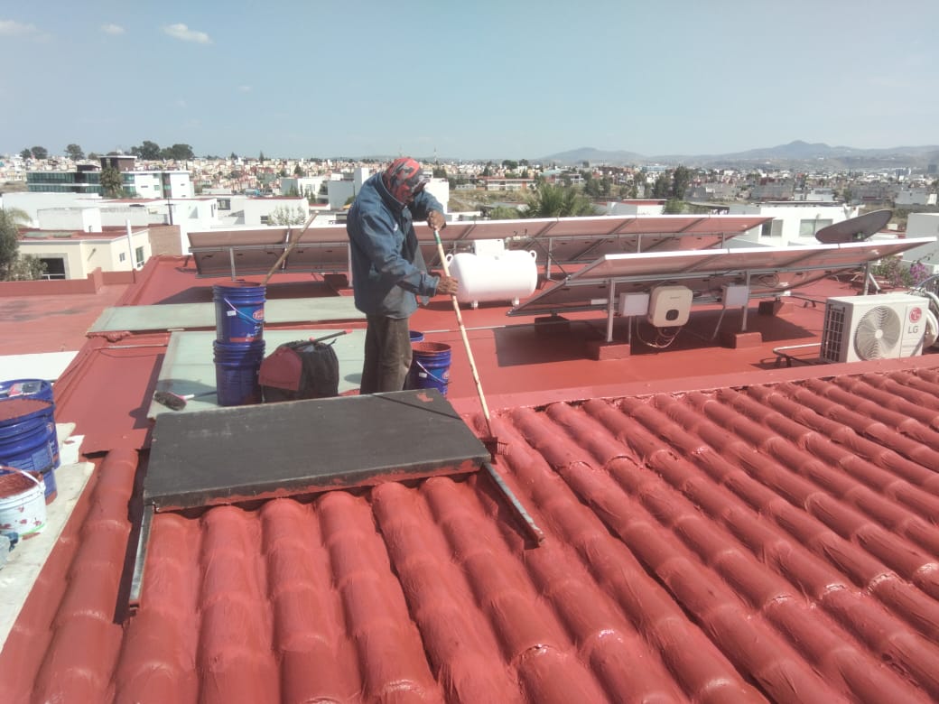 Técnico aplicando impermeabilizante en azotea